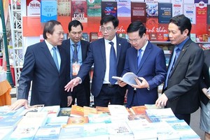 Politburo member and Head of the Party Central Committee's Commission for Communications and Education Vo Van Thuong (2nd, R) visits display booths at the 5th Vietnam Book Day. (Photo: Sggp)