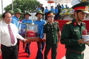 Local staff and army personnel carry the coffin containing a set of remain. (Photo:Sggp)