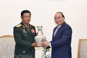 Prime Minister Nguyen Xuan Phuc (R) presents a gift to Sen. Lt. Gen. Suvon Luongbunmi, Deputy Defence Minister and Chief of the General Staff of the Lao People’s Army, at their meeting on May 14 (Photo: VNA)