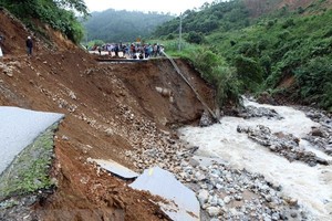A section of National Road 32 is destroyed by flood (Photo: VNA)
