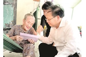 Deputy secretary of the Ho Chi Minh City Party Committee Tat Thanh Cang visits a Vietnamese heroic mother.  (Photo: Sggp)