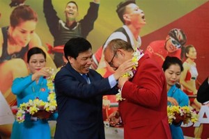 Minister of Culture, Sports and Tourism Nguyen Ngoc Thien (L) presents flowers to head coach of the Olympic men's football team Park Hang-seo (Photo: VNA)