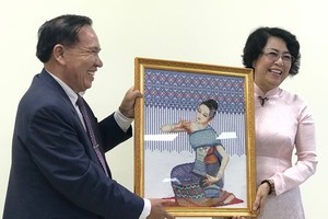 Chairman of the Lao Front for National Construction – Vientiane chapter Bounthieng Khounsy (L) presents a picture to To Thi Bich Chau, Vice President of the Vietnam Fatherland Front – Ho Chi Minh City chapter (Source: daidoanket.vn)