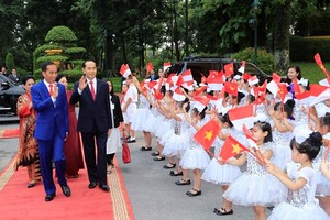 Indonesian President Joko Widodo (L) is welcomed by Vietnamese children at the official welcome ceremony for him and his spouse in Hanoi on September 11 (Photo: VNA)
