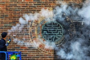 Many of the nearly 200-year-old gate's bricks (L) have regained their bright red color after 15 days. (Photo: vnexpress.net)