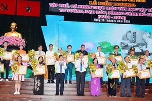 Secretary of HCM City Party Committee Nguyen Thien Nhan and chairman of the municipal People’s Committee Nguyen Thanh Phong present certificates of merit to honored individuals and units. (Photo: Sggp)