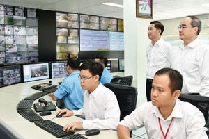 Secretary of HCMC Party Committee Nguyen Thien Nhan  (Standing,R ) visits the Traffic Control and Monitoring Center in HCMC. (Photo: Sggp)