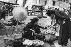 A vendor fills the baskets with goods.