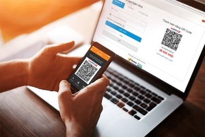 A customer makes payment by QR code for his order online. (Photo: VNA)
