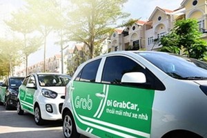 Cars which provide passenger transportation via ride-hailing platforms like Grab will have to put on top TAXI sign or carry logo stickers showing that they are contract vehicles. (Photo: VNA)