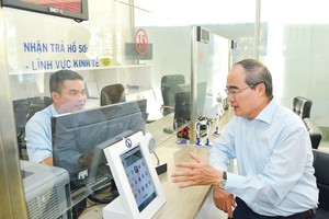 Secretary of HCMC Party Committee Nguyen Thien Nhan talks with an official of the People’s Committee of District 12.