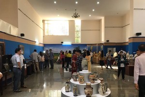 Visitors contemplate antiques in the exhibition. (Photo: SGGP)