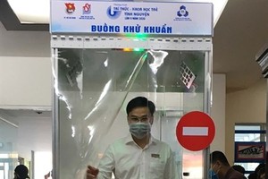 A man tries to use a mobile disinfection chamber at a launching ceremony held in HCM City on March 18. (Photo: VNA)
