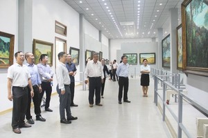Vice Chairman of the municipal People’s Committee, Duong Anh Duc leads a delegation of officials to visit Mr. Bui Van Ngo's exhibition room. (Photo: SGGP)