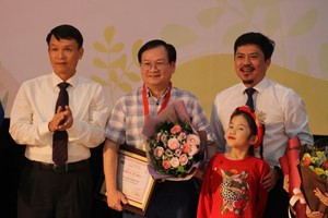 Children author Nguyen Nhat Anh (C) receives the Cricket Knight prize.