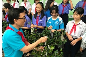 Child Protection Specialist, Tran Cong Binh hands over trees to students at the event. (Photo: SGGP)