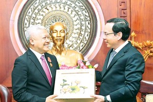 Secretary of the Party Committee of HCMC, Nguyen Van Nen (R) presents a gift to Indonesian Ambassador to Vietnam Ibnu Hadi. (Photo: SGGP)