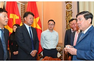Chairman of the municipal People’s Committee Nguyen Thanh Phong (R) receives General Director and Chief Operating Officer of Uniqlo Vietnam, Osamu Ikezoe. (Photo: SGGP)
