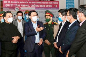 Secretary of Hanoi's Party Committee Vuong Dinh Hue (C) and Hanoi's leaders monitor the implementation of measures to prevent and control Covid-19 in Nam Tu Liem District. (Photo: SGGP)