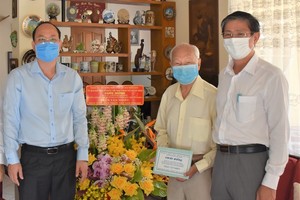 Deputy Secretary of the HCMC Party Committee Nguyen Ho Hai (L) visits Hero of Labor, Pharmacist Tran Van Nhieu. (Photo: SGGP)