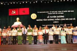 Secretary of the Party Committee of HCMC, Nguyen Van Nen presents certificates of merit and medals to outstanding individuals and organizations. (Photo:SGGP)