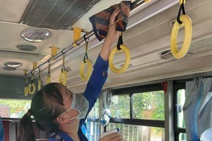 A worker is cleaning and disinfecting a bus. (Photo: SGGP)