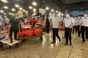 Vice Chairman of the HCMC People’s Committee Duong Anh Duc leads a delegation to conduct an inspection of the epidemic prevention and control at Binh Dien whosale market. (Photo: SGGP)