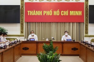 Deputy PM Truong Hoa Binh (L) and Chairman of the HCMC People's Committee Nguyen Thanh Phong  at the meeting ( Photo: SGGP)