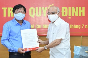 Head of the Propaganda Department of the City Party Committee, Phan Nguyen Nhu Khue (R) hands over the appointment decision to Mr. Tang Huu Phong. (Photo: SGGP)