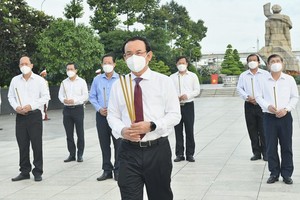 The delegation of HCMC's leaders offer flowers and incenses to fallen soldiers at the HCMC Martyrs Cemetery in Thu Duc City. (Photo: SGGP)