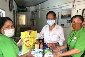 Presenting gifts to poor people (Photo: VNA)