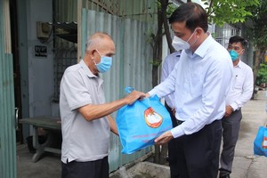 Vice Chairman of the HCMC People’s Committee Le Hoa Binh (R) present gift to a resident in a green zone in Vinh Loc B Commune. (Photo: SGGP)