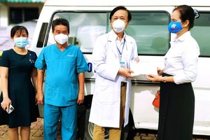Writer Bich Ngan presents VND100 million to healthcare workers of the Thu Duc General Hospital. (Photo: SGGP)