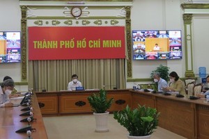 Chairman of the municipal People’s Committee, Nguyen Thanh Phong (C) attends at the online conference in the head office of the HCMC People's Committee. (Photo: SGGP)