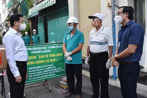 Head of the HCMC Party Committee's Inspection Commission Duong Ngoc Hai (L) visits a green zone in Tan Phu District. (Photo: SGGP)
