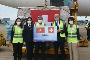 Deputy Health Minister Nguyen Truong Son (3rd, L) receives Covid-19 medical aid from Martin Urs Maier (2nd, R), Switzerland Consul General in HCMC. (Photo: SGGP)