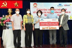 Chairwoman of the Vietnam Fatherland Front of HCMC To Thi Bich Chau  (C) and  Vice Chairwoman of the HCMC People's Committee Phan Thi Thang (2nd, L) receive 100 ventilators from the Sovico Group and HDBank. (Photo: SGGP)