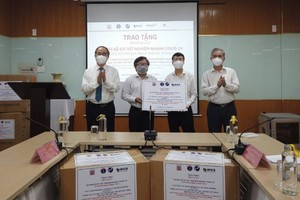 Professor Nguyen Thien Nhan (L) and representatives of HCMC authorities, HCMC Pasteur Institute and VGU attend the receiving event. (Photo: SGGP)