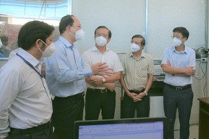 Deputy Secretary of the HCMC Party Committee Nguyen Ho Hai (2nd, L) talks with healthcare workers of the Covid-19 treatment field hospital in District 8. (Photo: SGGP)