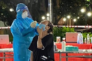 Medical workers take samples for Covid-19 testing in HCMC"s District 12. (Photo: SGGP)