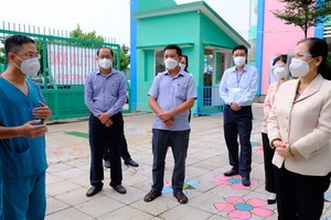 Chairwoman of the HCMC People's Council Nguyen Thi Le (R) talks with Military medical officers who have been delegated to support Hoc Mon District in the fight against Covid-19 by the Ministry of Defense. (Photo: SGGP)