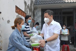 Vice chairman of the HCMC People’s Committee Duong Anh Duc offers gifts to local people in Ba Diem Commune. (Photo: SGGP)