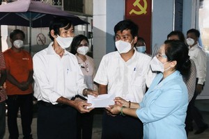 Chairwoman of the HCMC People's Council Nguyen Thi Le offers gifts to officials to the Vo Thi Sau Ward in District 3. (Photo: SGGP)