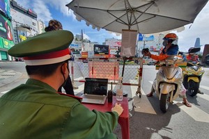 Residents provide health declaration QR Code at the checkpoint at the Phu Dong intersection. (Photo: SGGP)