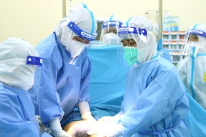 A pregnant woman infected with SARS-CoV-2 having a cesarean section in Hoan My Covid-19 Treatment Hospital (Photo: SGGP)