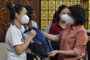 Chairwoman of the HCMC Chapter of the Vietnam Fatherland Front To Thi Bich Chau hands over presents to volunteers. (Photo: SGGP)
