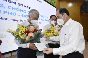 Director of the Department of Health of HCMC Tang Chi Thuong offers flowers to helthcare workers.