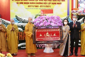 Chairwoman of the HCMC People’s Council Nguyen Thi Le (3rd, R) presents a gift to congratulate the Vietnam Buddhist Sangha's 40th anniversary. (Photo: SGGP)