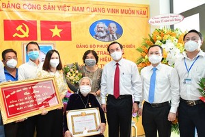 Secretary of the HCMC Party Committee Nguyen Van Nen (3rd, R) and Secretary of the Party Committee of Thu Duc City Nguyen Van Hieu (2nd, R) present the 75-year Party membership badge to Party member Mac Kim Cuc (C). (Photo: SGGP)