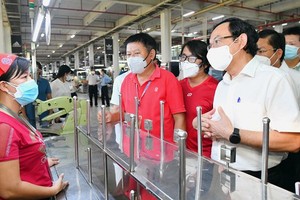 Secretary of the HCMC Party Committee Nguyen Van Nen talks with workers of PouYuen Vietnam Company. (Photo: SGGP)